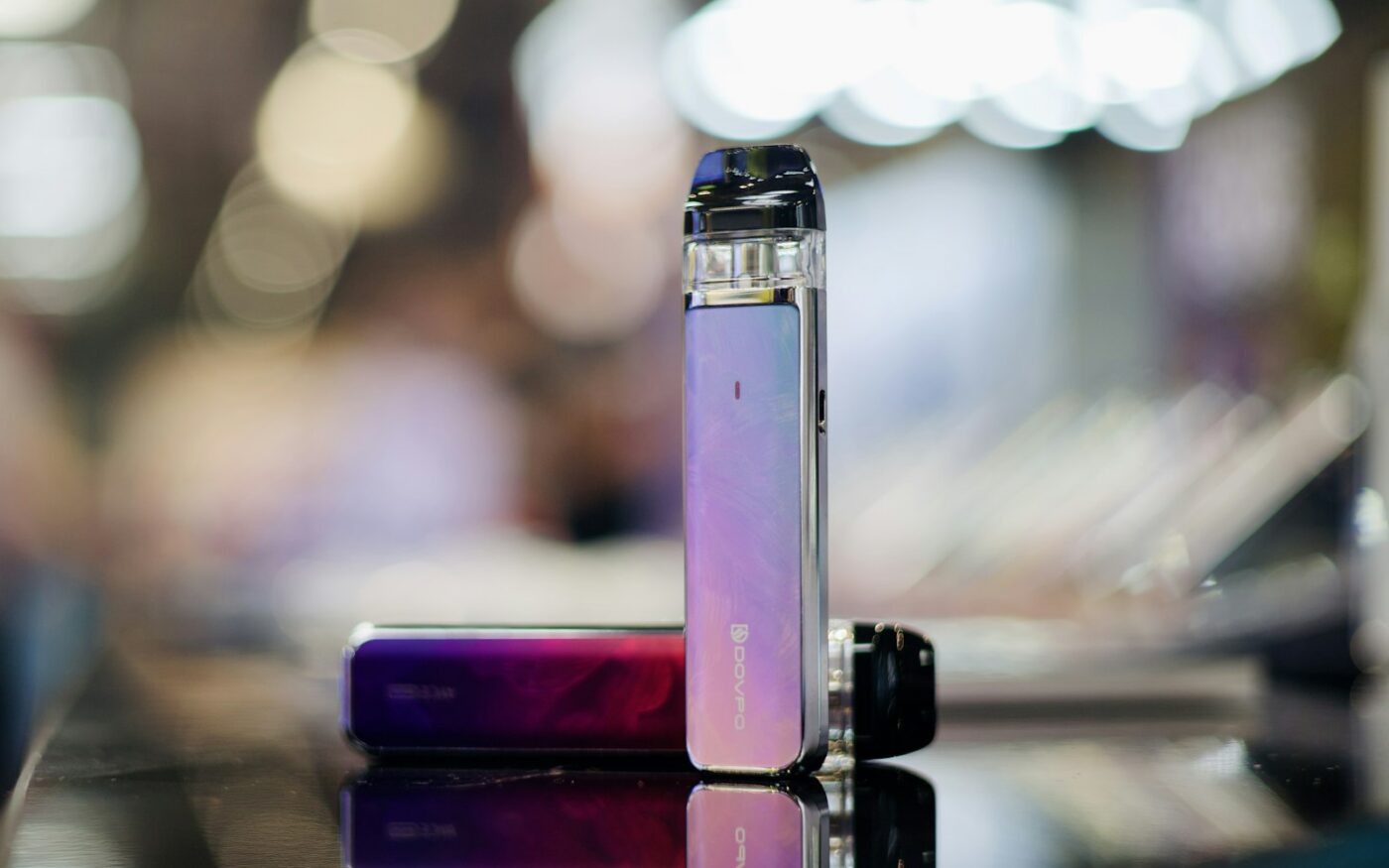 Two small devices on a table with bokeh lights