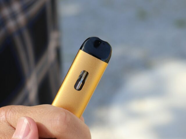 Hand holding a yellow pod device
