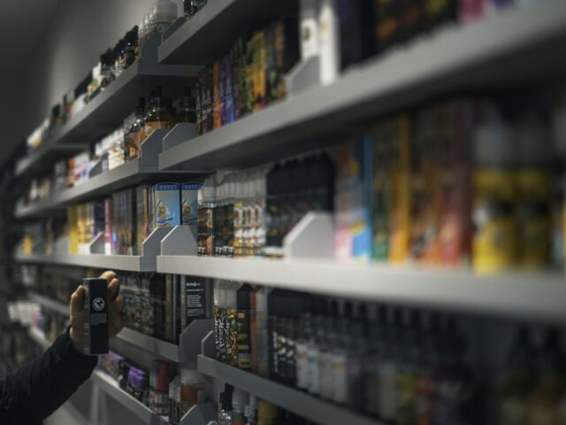 Shopper browsing a wall of vaping products