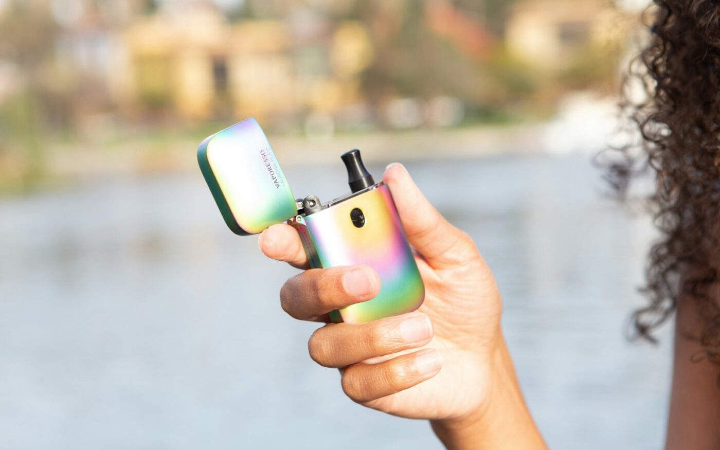 Hand holding a pod device next to a smartphone